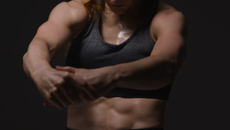 Close-Up-Studio-Shot-Showing-Chest-Of-Mature-Woman-Wearing-Gym-Fitness-Clothing-Doing-Stretching-Exercises